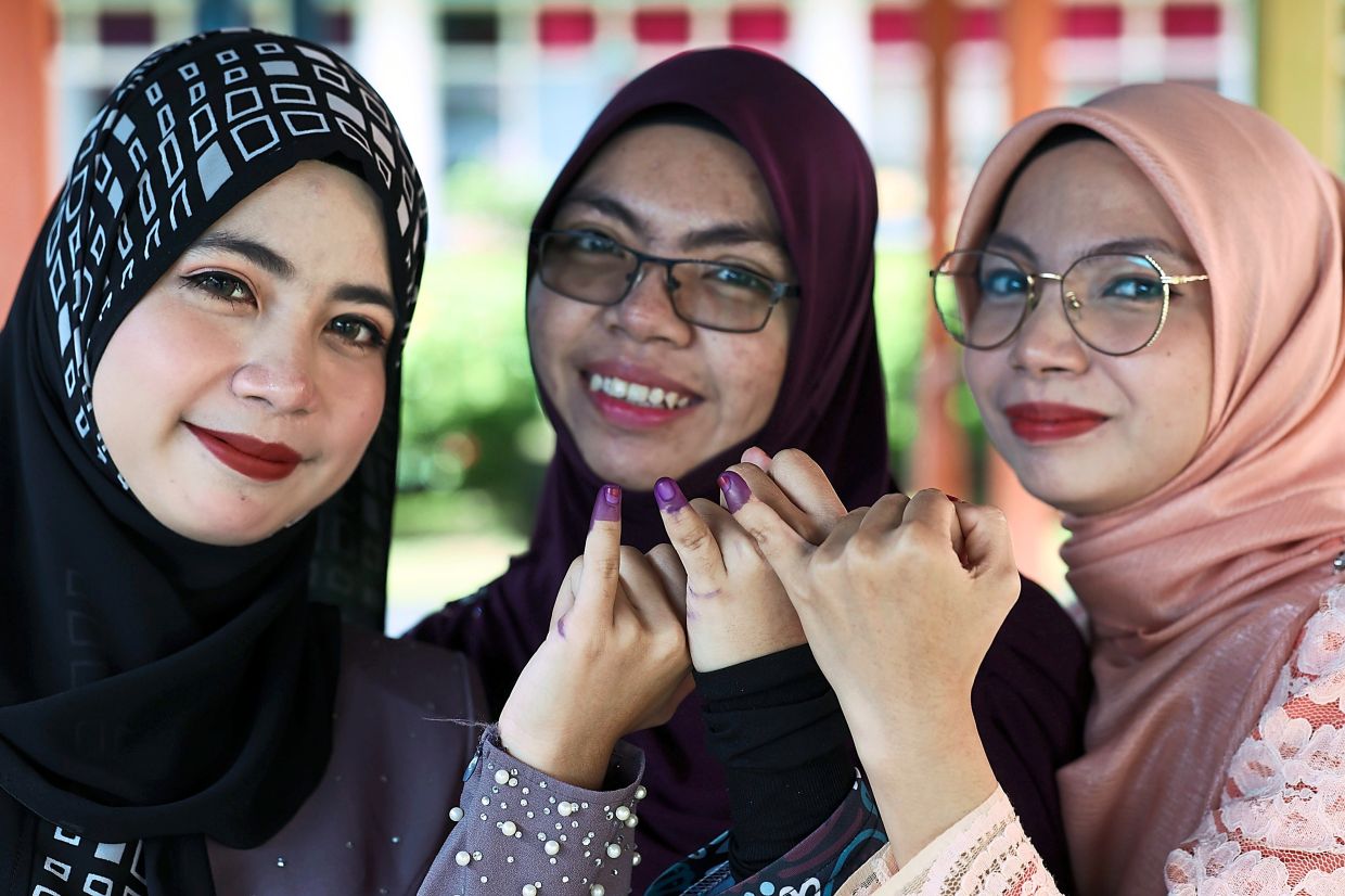 Done voting: Sisters (from left) Nur Hasmimi, Nur Annisa and Nur Izarani Abdul Razak showing their inked pinkies after voting at SMK Tanjung Gemuk in Kuala Rompin. — Bernama