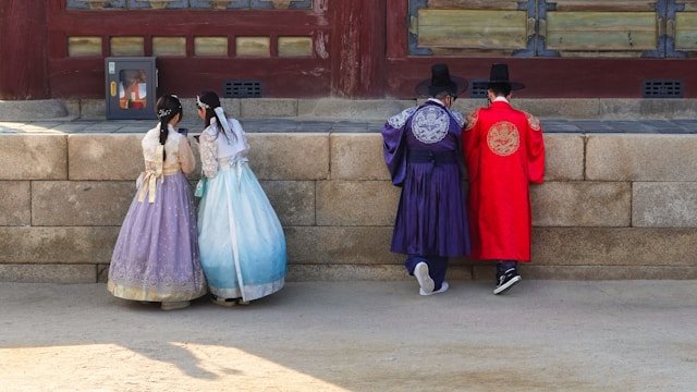 Korean MZ generation youth on smartphones illustrating the digital, mobile-first cohort whose KakaoTalk and Instagram habits push new Korean slang into the mainstream