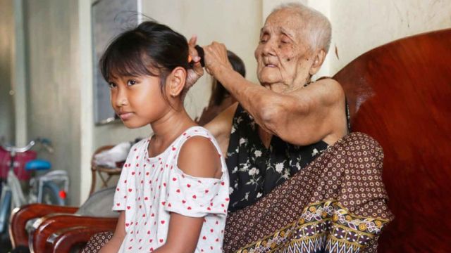 13_11_2023_A-grandmother-combs-the-hair-of-her-granddaughter-at-in-Boeung-Kengkang-district.-HENG-CHIVOAN.jpg