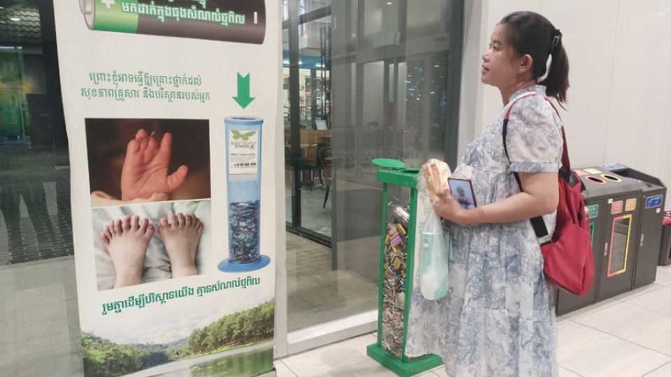 18_11_2024_a_pregnant_woman_reads_educational_messages_on_battery_waste_at_aeon_mall_1_in_phnom_penh_phak_seangly.jpg