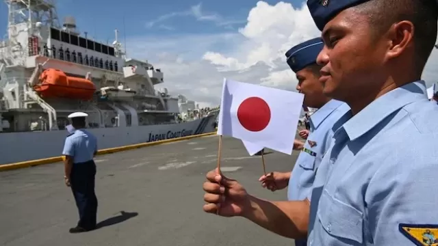 2023-06-05-Philippine-Coast-Guard-personnel-holding-Japanese-flags.webp
