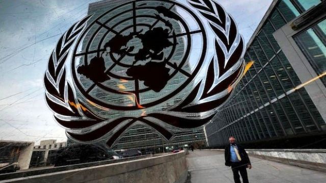 2023-06-28-Person-walking-outside-UN-headquarters-near-UN-logo.jpeg