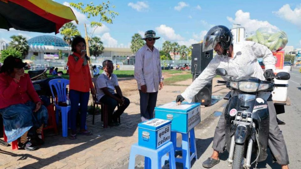 28_2_2024_a_man_offers_money_to_blind_signers_on_the_streets_of_phnom_penh_in_the_past_post_staff.jpg