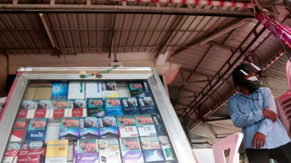 a_customer_waits_beside_a_cigarette_cabinet_in_the_capitals_daun_penh_district_in_2021._heng_chivoan.jpg