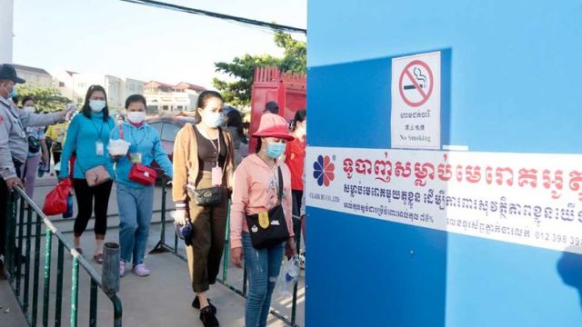 a_factory_security_guard_takes_the_temperature_of_workers_before_they_enter_a_factory_in_phnom_penhs_por_sen_chey_district_last_july._heng_chivoan.jpg