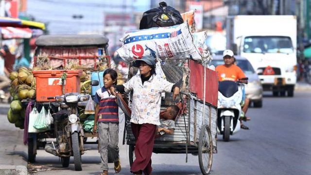 a_woman_pulls_her_cart_filled_with_recyclable_materials_in_meanchey_district_of_phnom_penh_in_april_2020._hong_menea.jpg