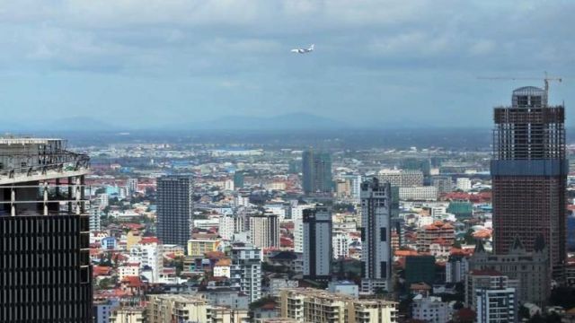 an_airplane_flies_over_the_tops_of_high-rises_in_phnom_penh_on_january_12._hong_menea.jpg