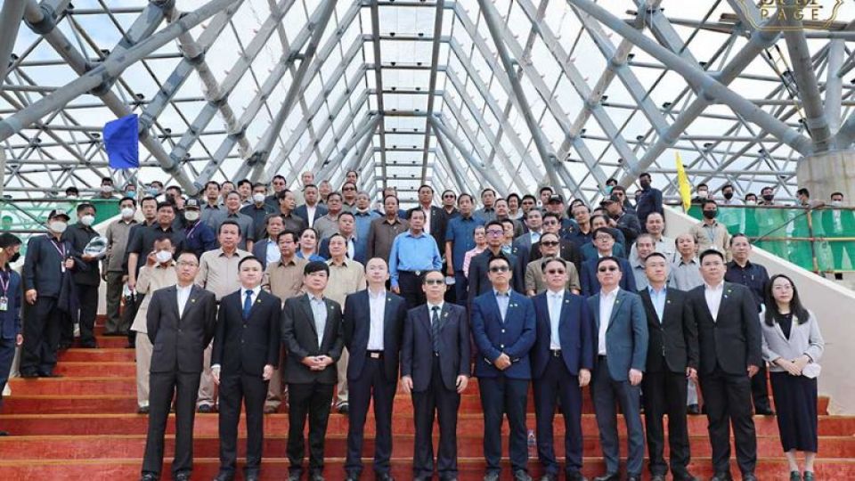 prime_minister_hun_sen_centre_donning_a_sky-blue_shirt_a_large_number_of_government_officials_and_other_attendees_pose_for_p.jpeg