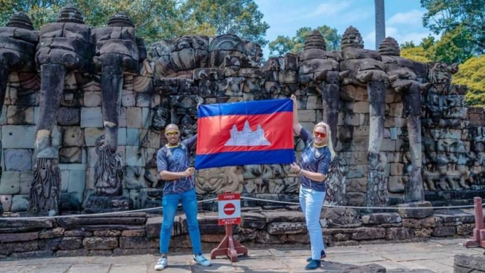 thiago_teixeira_left_and_his_wife_roma_maria_rozanska-steffen_hold_up_a_cambodian_flag_at_the_elephant_terrace_in_siem_reap_province_earlier_this_year._fb.jpg