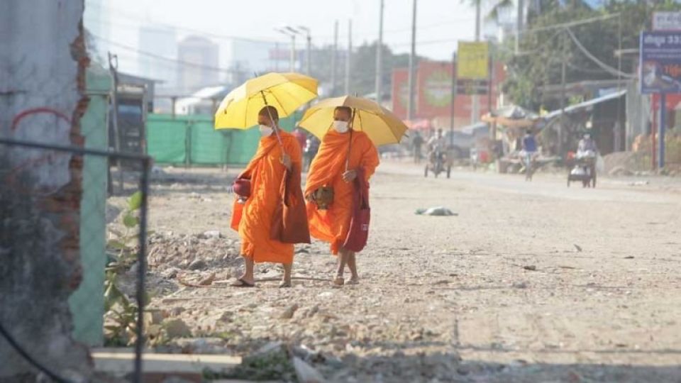 two_buddhist_monks_walk_through_russey_keo_district_to_collect_alms_on_a_hot_morning_recently._heng_chivoan.jpg